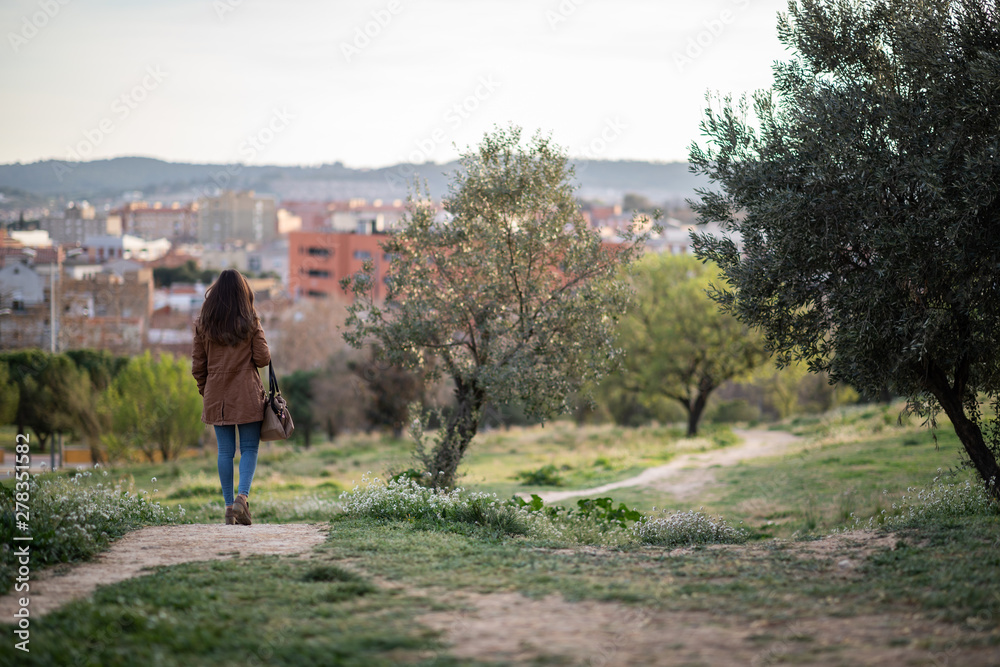 Beautiful woman standing on park during sunset Beautiful woman standing on park during sunset