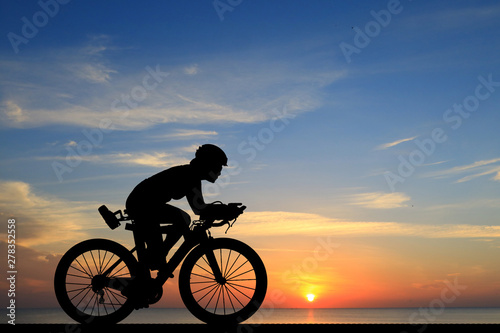 Silhouette Cycling on blurry sunrise sky background.