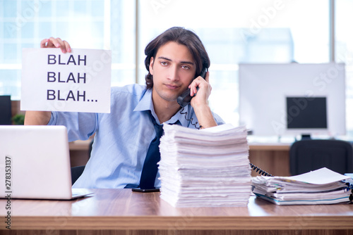 Canvas Print Young employee unhappy with excessive work