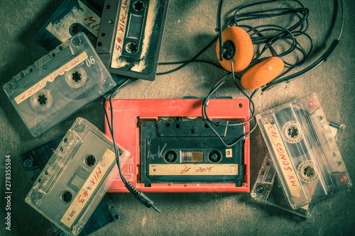 Retro audio cassette with headphones and red walkman