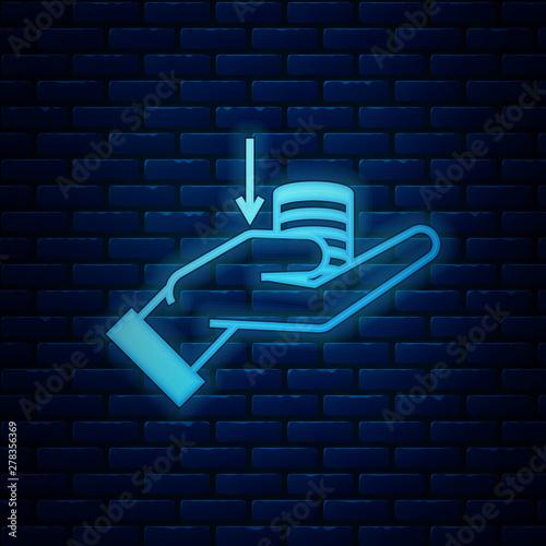 Glowing neon Money on hand icon isolated on brick wall background. Palm holds cash with down. Cash salary decrease. Vector Illustration