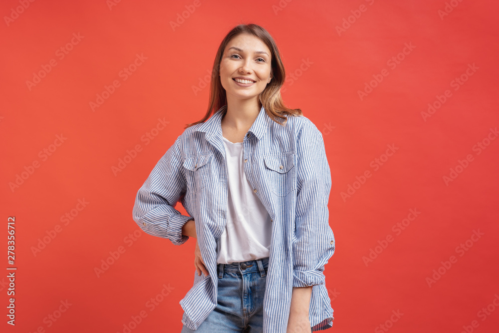 Pretty female model posing with a smiling face expression on red background Pretty female model posing with a smiling face expression on red background