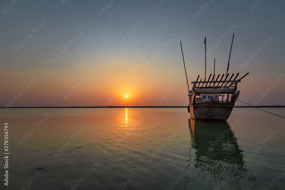 Beautiful Sunrise Boat in seaside with yellow and blue sky background. Dammam -Saudi Arabia