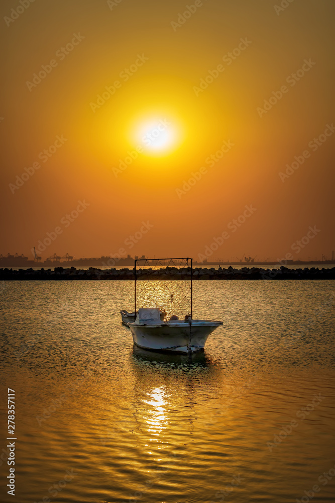 Naklejka premium Beautiful Sunrise Boat in seaside with yellow sky. Dammam -Saudi Arabia