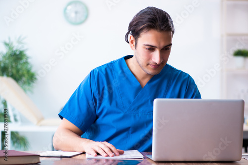 Young male doctor in telehealth concept  photo