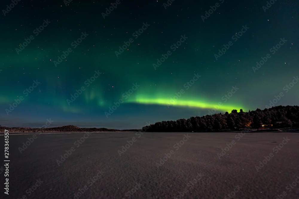 ooking across a frozen lake to the northern lights