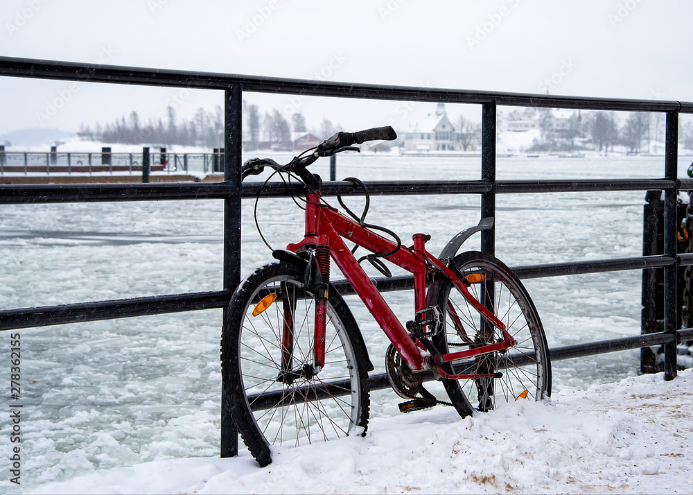 Red bike, leans against the harbour railing Red bike, leans against the harbour railing