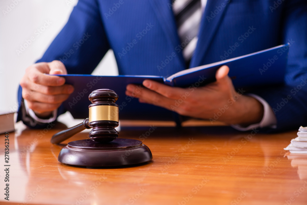 Young male judge sitting in courtroom Young male judge sitting in courtroom