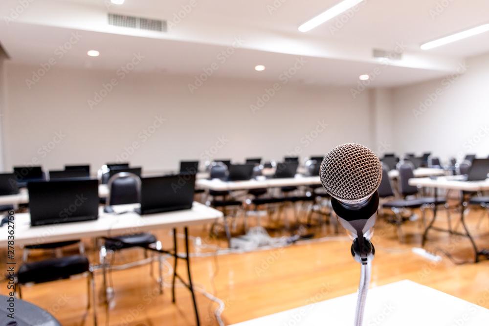 Microphone and Laptop on abstract blurred of speech in seminar room Microphone and Laptop on abstract blurred of speech in seminar room