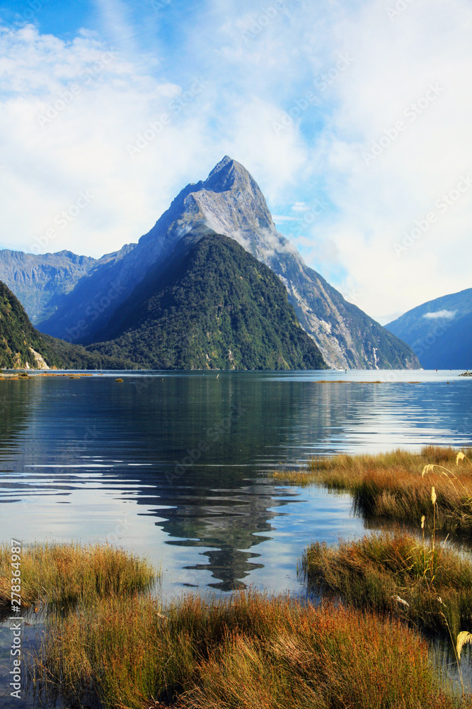 Mitre Peak reflected in the calm waters of Milford Sound, a world class tourist destination in New Zealand.