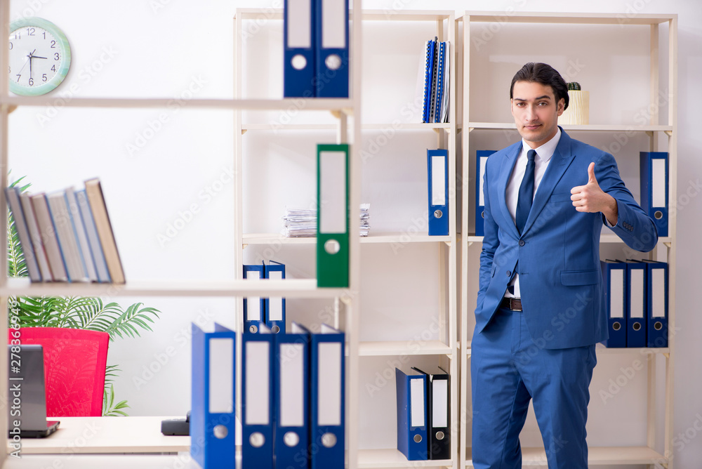 Young handsome employee in the office Young handsome employee in the office