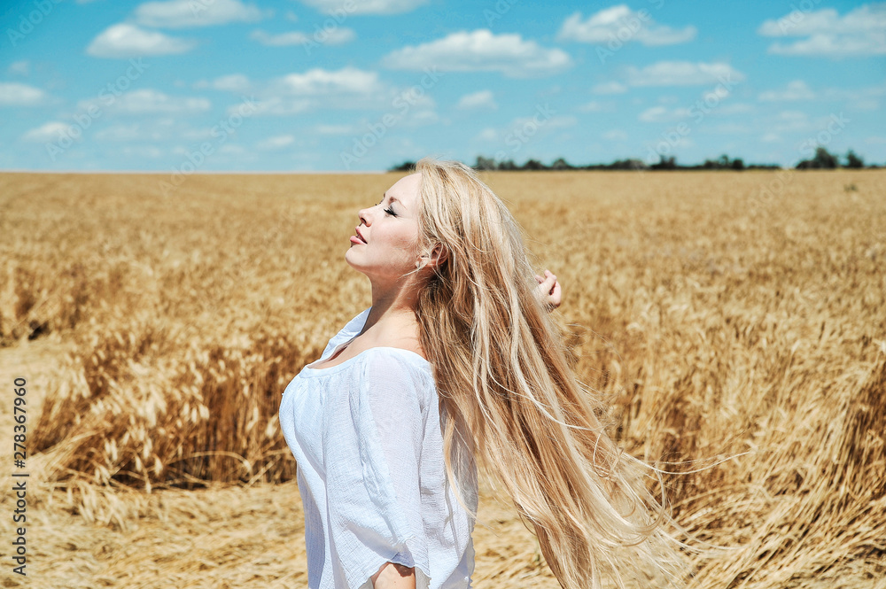 Beautiful girl in white clothes posing on the field Beautiful girl in white clothes posing on the field