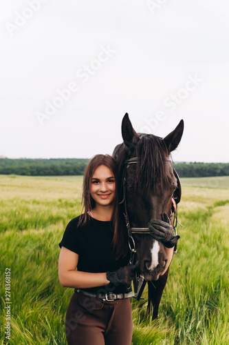 A girl and a young sports horse in the nature