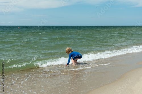 little girl by the sea bright sunny day blue sky