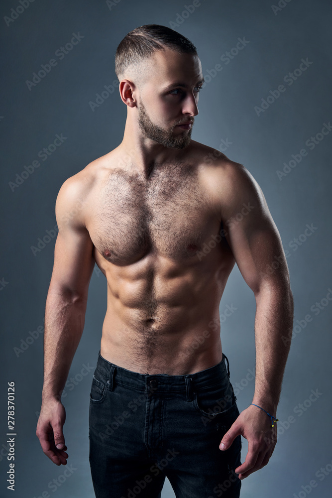 Fototapeta premium Muscular shirtless man standing with hands in pockets