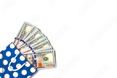 Isolated 100 US dollars banknotes bills are coming out of a blue paper bag on white background. Shopping sales concept. Copy space place for text photo