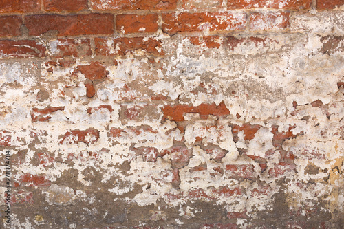 old shabby damaged plaster on the brick walls of houses close-up