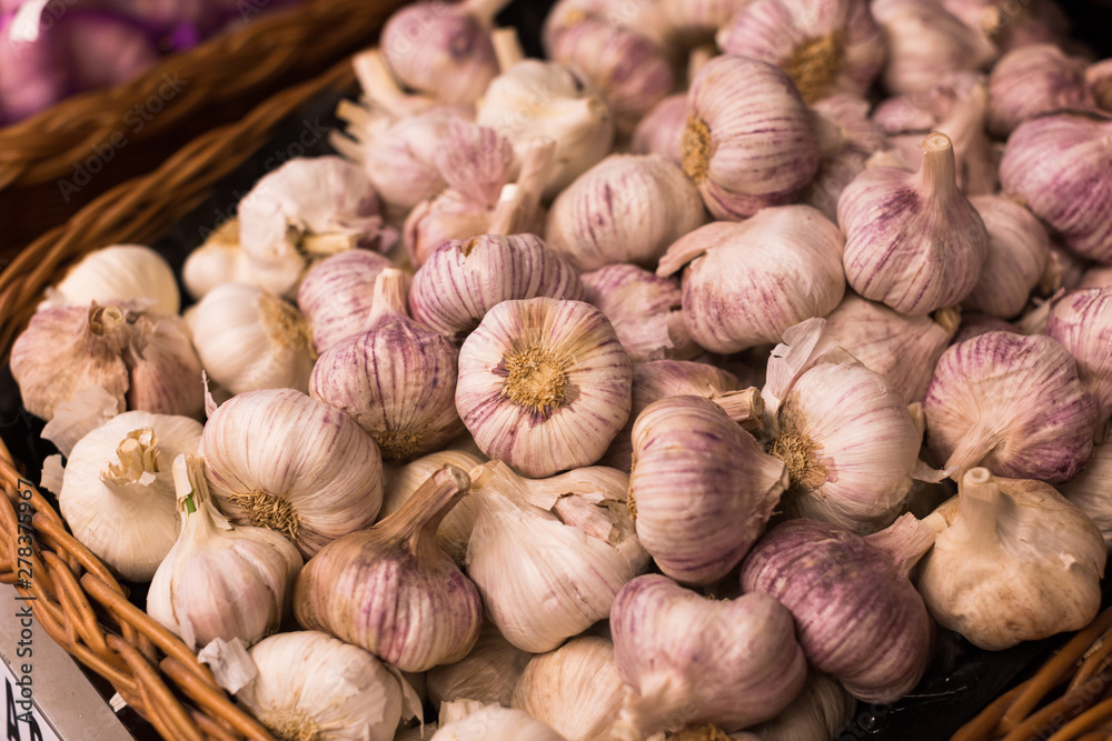 heads of fragrant garlic in baskets on market counter heads of fragrant garlic in baskets on market counter