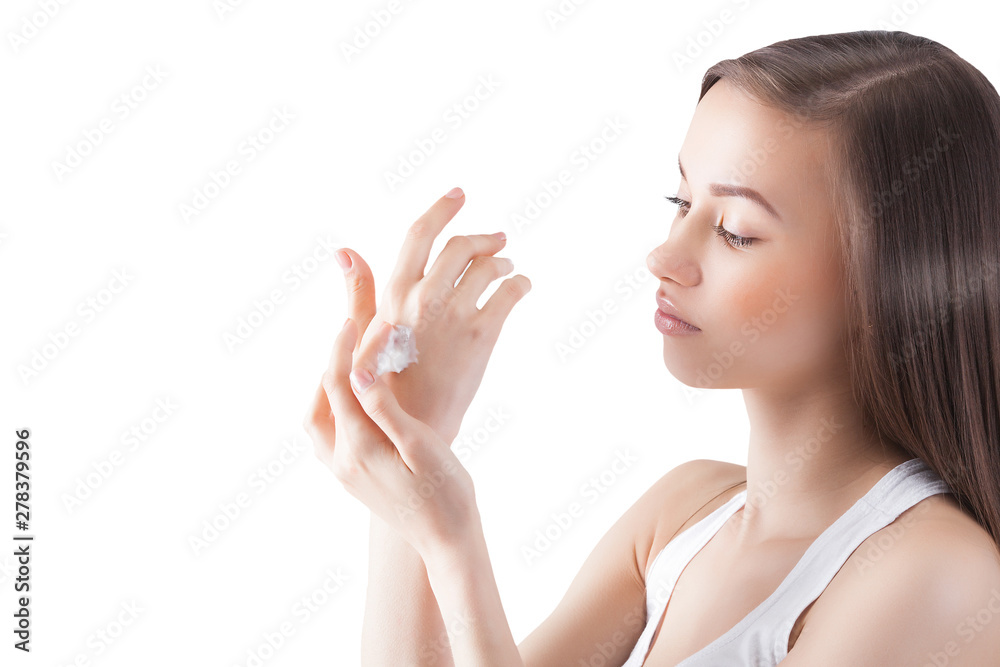 Young attractive woman applying hand cream. Closeup portrait of female on isolated white background. Young attractive woman applying hand cream. Closeup portrait of female on isolated white background.