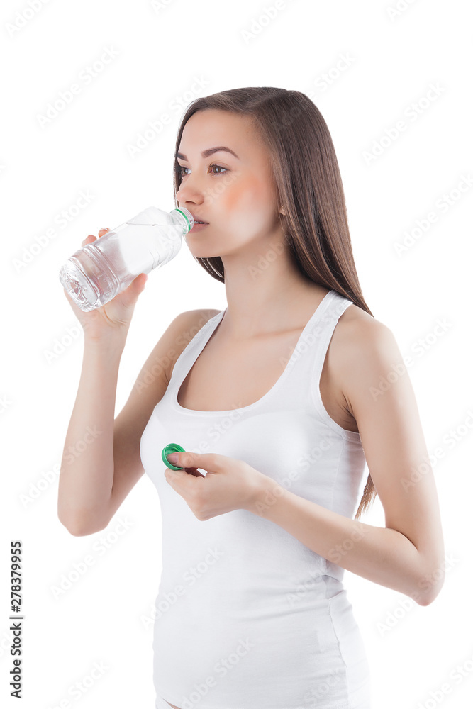 Young healthy woman drinking clean water. Female holding a bottle of water on isolated white background. Young healthy woman drinking clean water. Female holding a bottle of water on isolated white background.