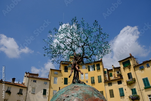 Srtuttura metallica di esibizione arte in Piazza dell' Anfiteatro a Lucca vista dal basso con istallazione albero e case tradizionali photo