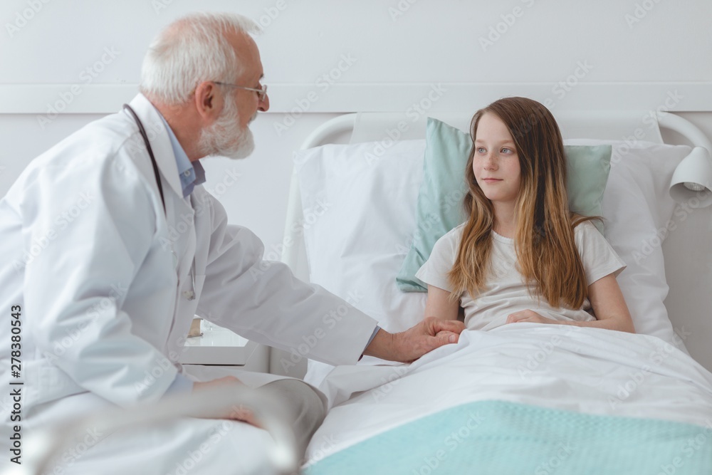 Fototapeta premium Doctor comforting a young girl in the hospital
