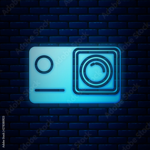 Glowing neon Action extreme camera icon isolated on brick wall background. Video camera equipment for filming extreme sports. Vector Illustration