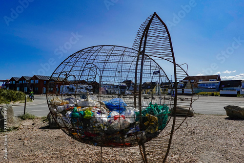 Hirtshals, Denmark A garbage can on the beach is made to look like a fish and is filled with plastic garbage to raise awreness of plastic in the oceans. photo