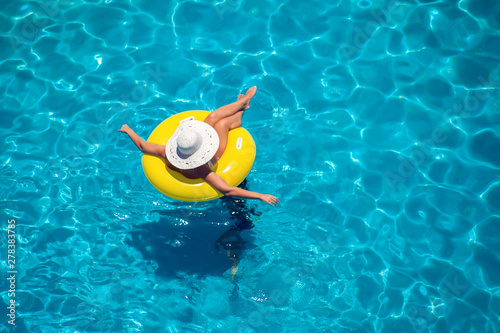 Woman swims on the inflatable circle in the pool. Summer and holiday concept