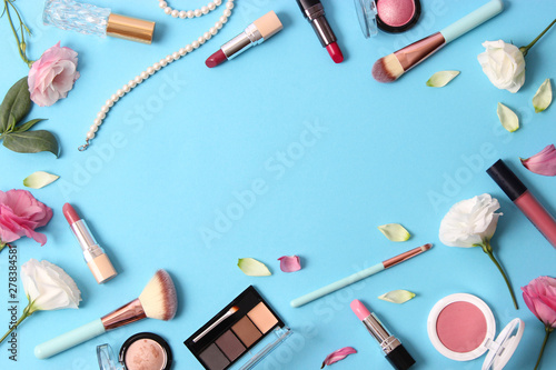 cosmetics and flowers on a colored background top view.
