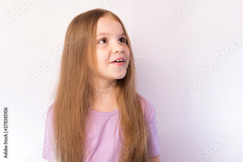 The little girl stares up at a light background © Artsiom P