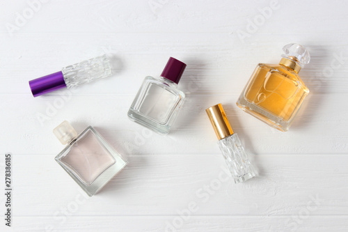 set of different perfumes on a light background top view.