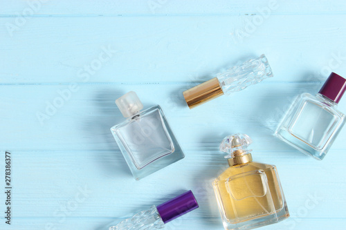 set of different perfumes on a colored background top view.