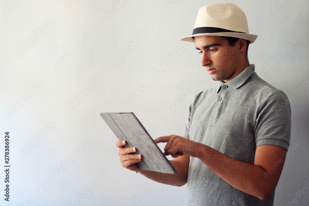Man dressed in gray using a tablet.