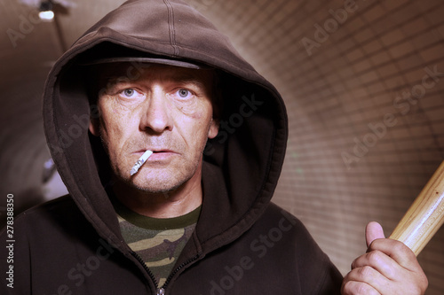 Bilde på lerret Older addict man in black hooded shirt with weapon