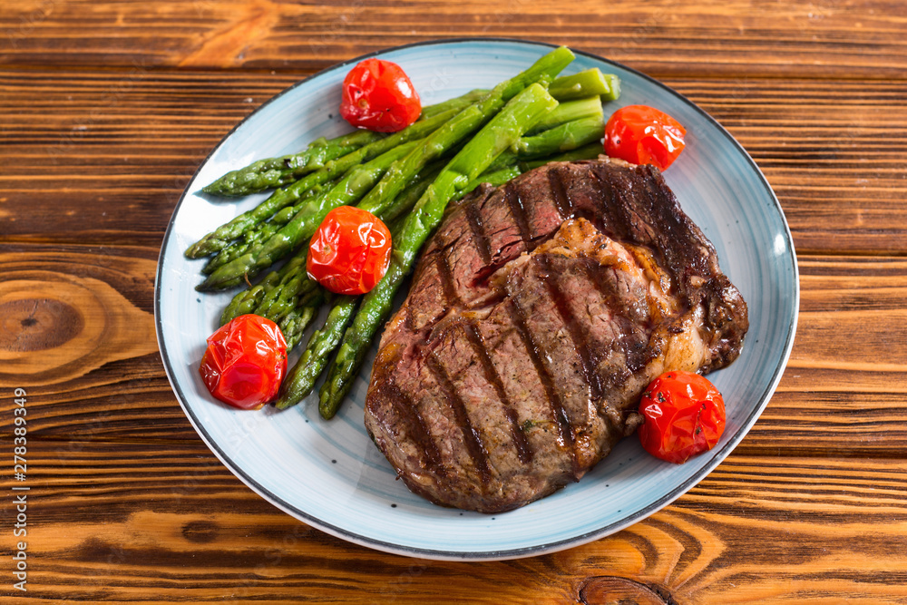 Grilled beef steak ribeye with cherry tomatoes and asparagus Grilled beef steak ribeye with cherry tomatoes and asparagus