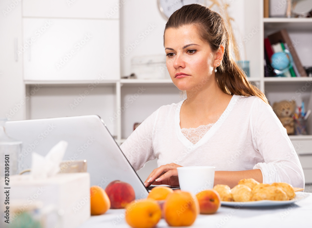 Woman sitting at table with peaches and  cup of tea in morning