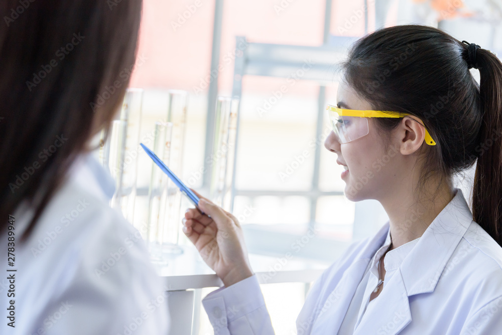 Asian young female working and research scientist together. Asian young female working and research scientist together.