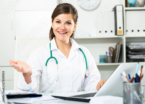 Smiling woman doctor working effectively in her office