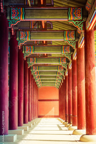 The repetition of columns at the Gyeongbok Royal Palace in Seould, South Korea.  The red columns with ornate ceiling draws the viewers eyes to the far end of the room. photo