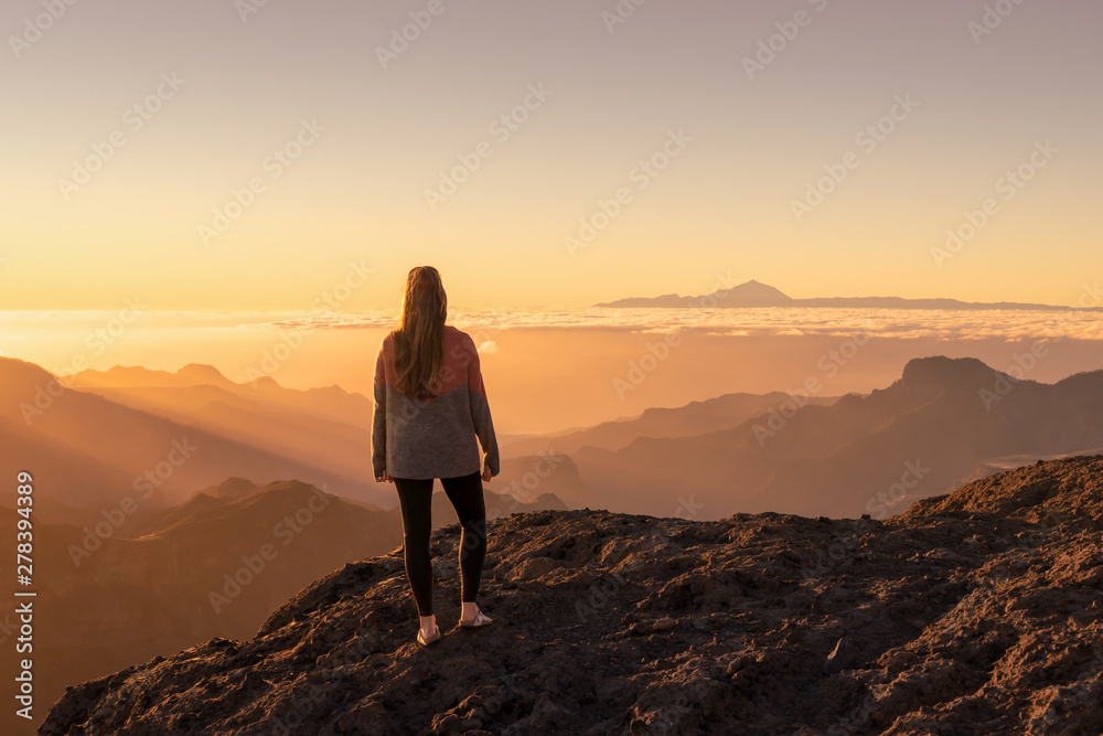 Happy young woman standing and enjoying life at sunset in mountains - gran canaria, spain Happy young woman standing and enjoying life at sunset in mountains - gran canaria, spain