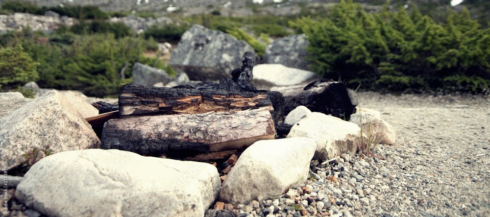 Close up on wood campfire surrounded by rocks in Canada Close up on wood campfire surrounded by rocks in Canada
