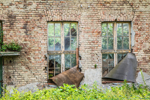 Wall of a ruined house with broken windows