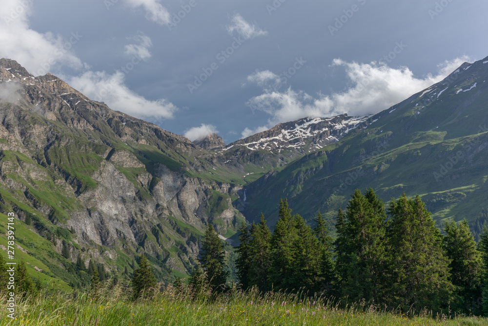 A waterfall in the Alps near Piz Beverin in Switzerland at the center of a valley - 1