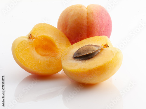 tres albaricoques enteros y abiertos. apricots fruit on white background 