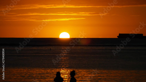 ハワイの夕日と人影と船 © Hidehiro