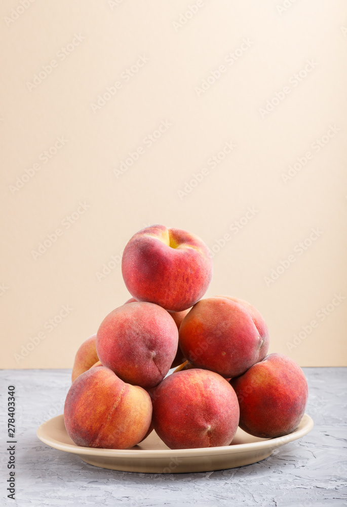 Fresh peaches on a plate on gray and orange pastel background. side view. Fresh peaches on a plate on gray and orange pastel background. side view.