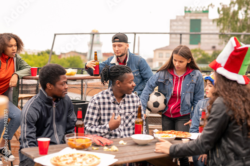 Group of young friendly sports fans gathered together outdoors