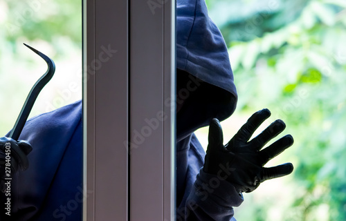Obraz na płótnie A burglar tries to break into a house in bright daylight