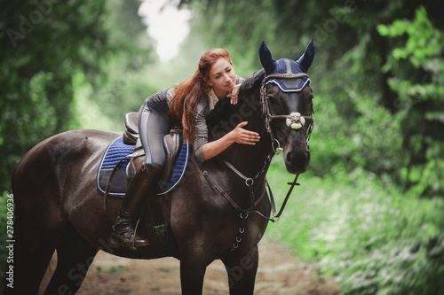 portrait of attractive woman and black hanoverian stallion horse